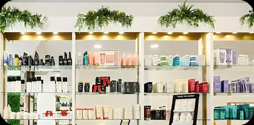 Estanterías con productos profesionales de peluquería y plantas en el salón Menta Beauty Place